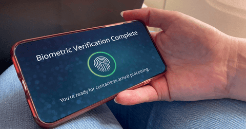 Close up of mobile phone screen stating "Biometric Verification Complete" and fingerprint symbol