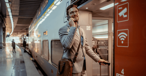 Man talking on the phone to an AI agent in a train station